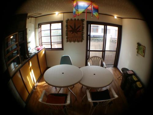 two tables and chairs in a kitchen with a kite at Guesthouse Base Okinawa in Naha