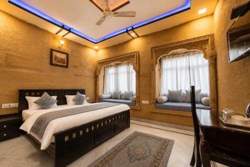 a bedroom with a king sized bed and windows at Hotel Saffron Diamond in Jaisalmer