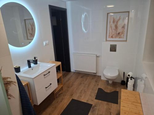 a bathroom with a white sink and a toilet at Dom nad Morzem 79 in Stegna