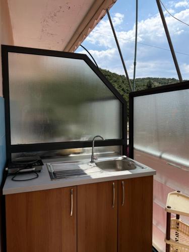 a kitchen with a sink and two large windows at Moliana Bunec in Himare
