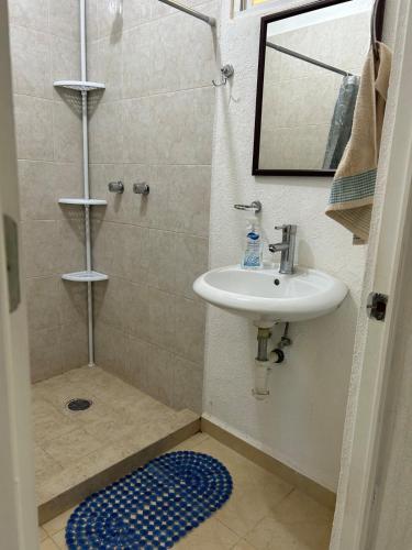 a bathroom with a sink and a shower with a mirror at Comfortable apartment with pool near beaches in Acapulco