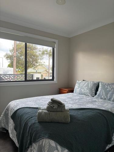 a bedroom with a bed with a large window at Deni's Home in Parkes