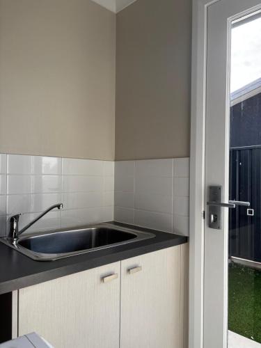 a kitchen with a sink and a window at Deni's Home in Parkes