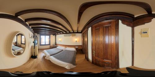 a bedroom with two beds in a room with a ceiling at Hostería La Antigua in Potes