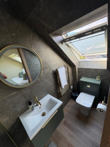 a bathroom with a sink and a mirror and a toilet at Coorie-Tigh in Connel