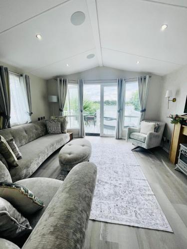 a living room with a couch and a table at Lakeside Bliss with Fishing Peg and Hot Tub in Tattershall
