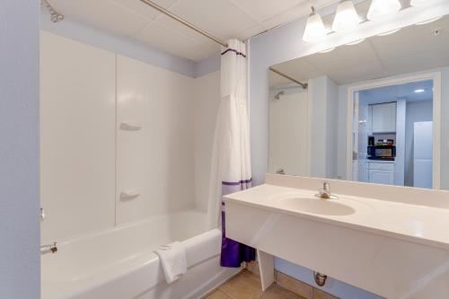 a bathroom with a sink and a tub and a mirror at Bonita Beach Hotel in Ocean City