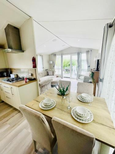 a kitchen and dining room with a wooden table and chairs at Lakeside Bliss with Fishing Peg and Hot Tub in Tattershall