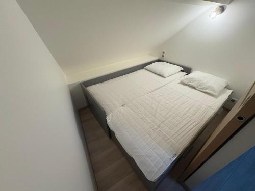 a small white bed in a small room at T2 Chez Mongery in Landreville