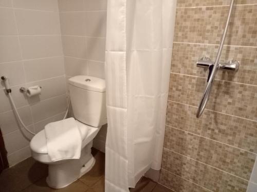 a bathroom with a toilet and a shower at Uniq Hotel in Yogyakarta