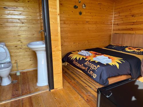 a bedroom with a bed and a toilet in a cabin at Eco Aura Areguni in Vardenis