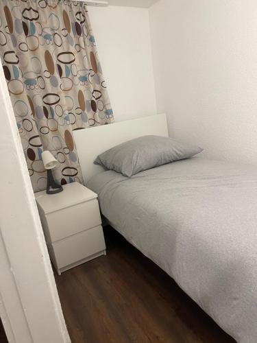 a small bedroom with a bed and a curtain with cups at Haus zum Bacchus Privatezimmer near Bahnhof Römisches Theater Mainz in Mainz