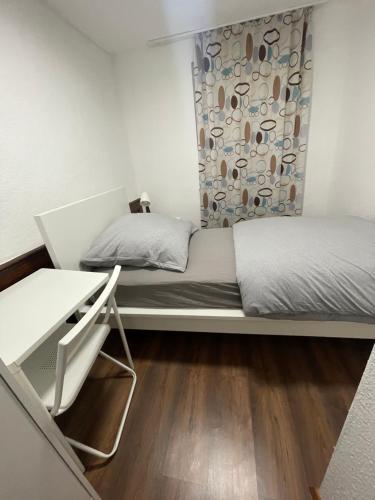 a bedroom with two beds and a desk at Haus zum Bacchus Privatezimmer near Bahnhof Römisches Theater Mainz in Mainz