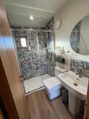 a bathroom with a shower and a toilet and a sink at Jacobite Cabin in Inverlochy
