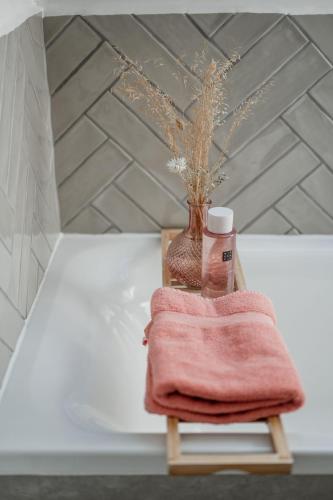 a towel and a vase on a table with a towel at Vakantiewoning Spoor 23 in Borgloon