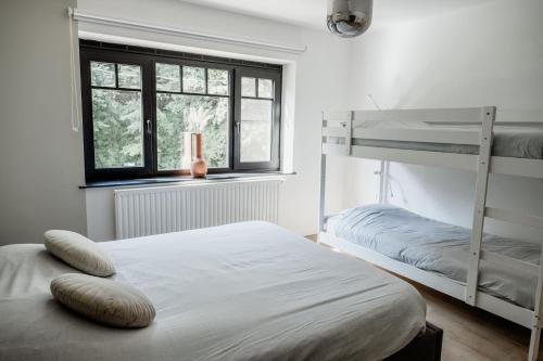 a bedroom with two bunk beds and a window at Vakantiewoning Spoor 23 in Borgloon