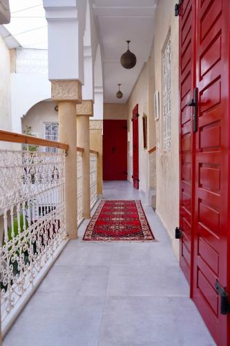 a hallway with red doors and a rug at Dar Halima in Rabat