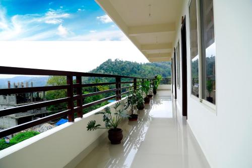 a balcony with potted plants on the side of a building at Skyrock Inn in Kattappana