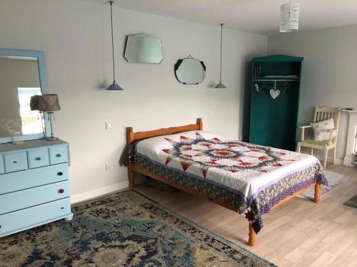 a bedroom with a bed and a dresser and a rug at Culoort Cottage - Malin Head in Malin Head