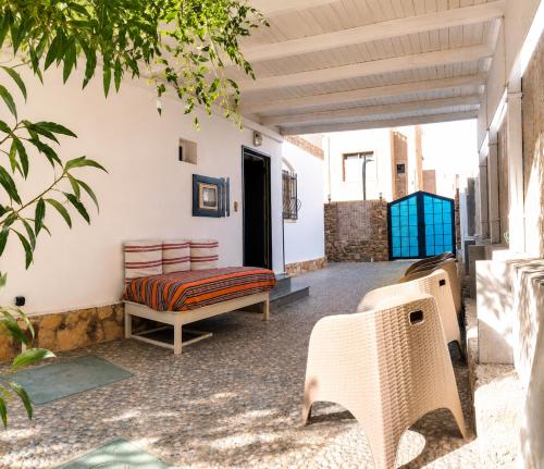 a patio with a bench and a table and chairs at Tarbouche House Dahab in Dahab
