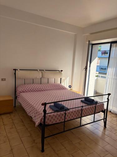a bedroom with a bed with a pink blanket and a window at Casa vacanza Emily in Pedaso