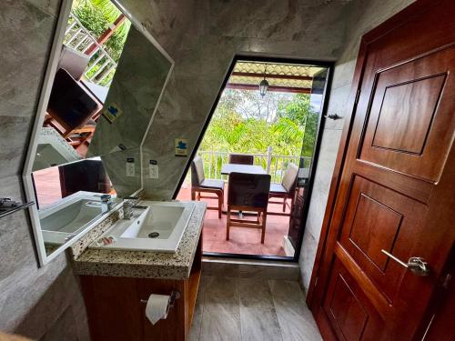 a bathroom with a sink and a door to a patio at Hosteria Arizona in Puyo