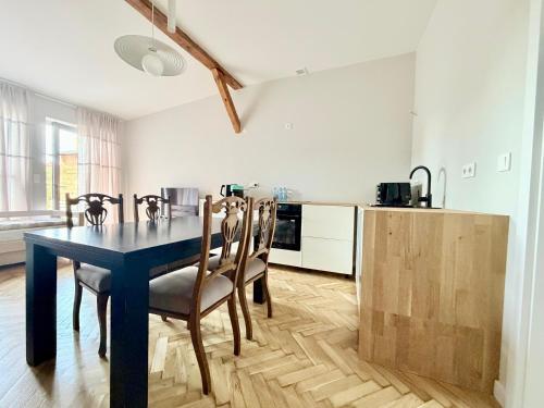 a dining room with a blue table and chairs at Apartamenty Stara Winiarnia in Wałcz