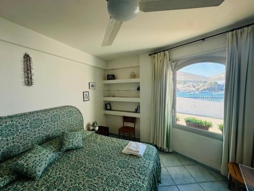 a bedroom with a couch and a window with a view at Salsedine - Immobilevante in Ponza