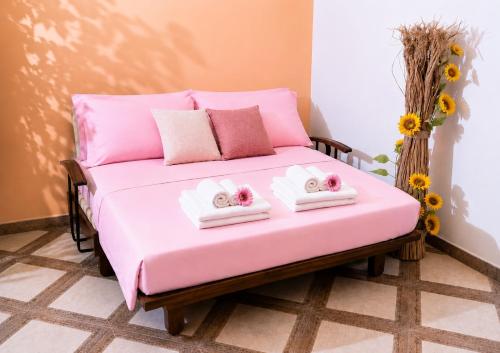 a pink bed with two hello kitty towels on it at Agriturismo Residence Molle con piscina in Carpignano Salentino