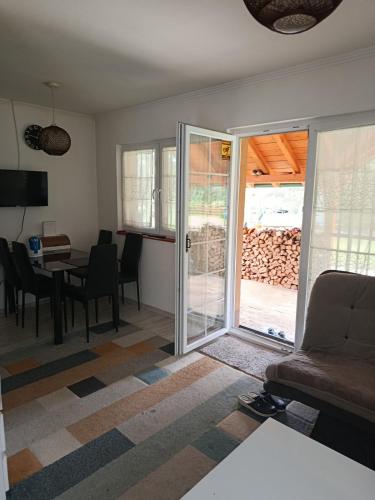 a living room with a couch and a table with chairs at Planinska Kuća Nišićka visoravan in Ilijaš