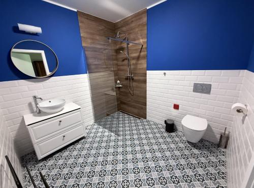 a bathroom with a sink and a toilet and a shower at Stara Fabryka Myślniew in Myślniew