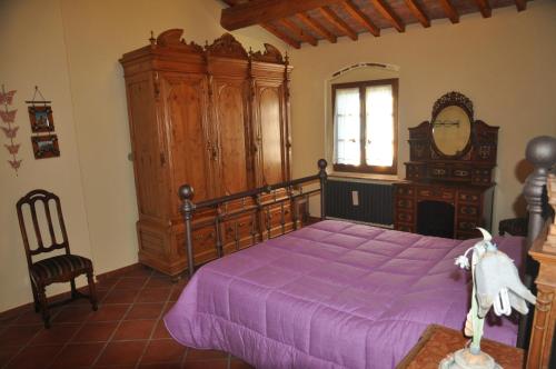 a bedroom with a large purple bed and a mirror at Casa della Madonna in Montaione