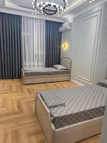 two beds in a room with a chandelier at NRG BI Sado in Salor Bekati