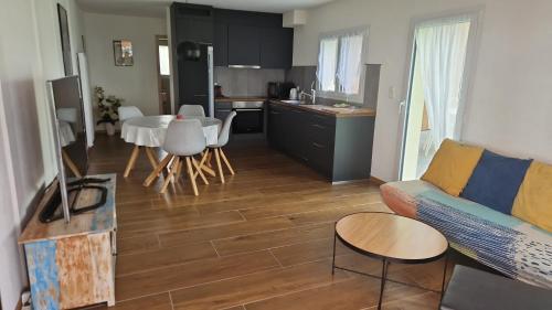 a living room with a couch and a table and a kitchen at Coup d'œil in Bullet