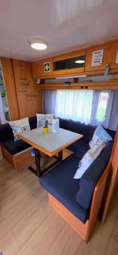 a dining room with a table in a caravan at Ella's Camper in Fontinha