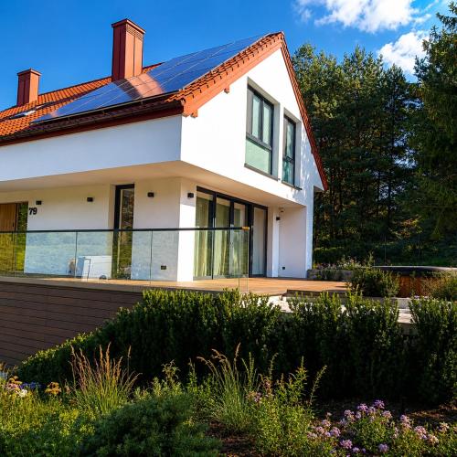 a white house with a solar roof at DARESTATE - dom rodzinny in Zgon
