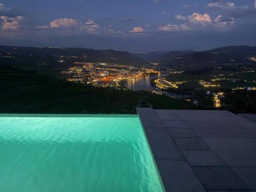 a view of a river and a city at night at Casa do Paço Suítes Douro Valley in Peso da Régua