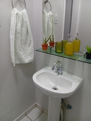 a bathroom with a sink and a mirror at Veneza Exclusive 101 in Ipatinga