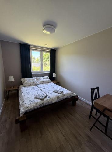 a bedroom with a bed and a table and a window at Stara Fabryka Myślniew in Myślniew