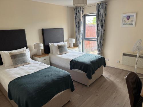 a bedroom with two beds and a window at Large four bedroom town centre house in Killarney