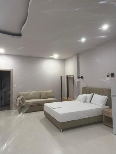 a bedroom with a large bed and a couch at Fatses in Nea Plagia