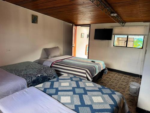 a group of three beds in a room at Hospedaje El Encanto in Zipaquirá