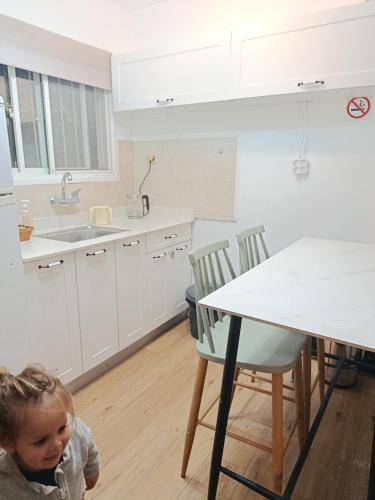 a little child in a kitchen with a table at Neoth Deshe 770 in Safed