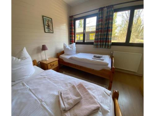a bedroom with two beds and two windows at Rückzugsort mit Terrasse, Eschede in Eschede