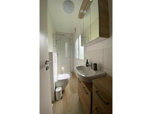 a white bathroom with a sink and a mirror at Ferienhaus mit Garten, Eschede in Eschede