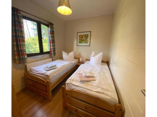 two beds in a small room with a window at Ferienhaus mit Garten, Eschede in Eschede