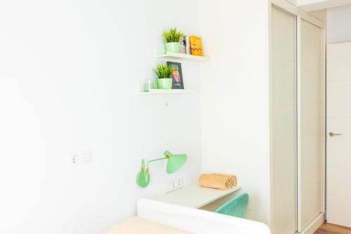 a white room with a desk and plants on the wall at Villa Martena in Cambados