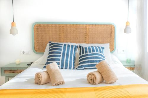 a bed with blue and white striped pillows on it at Villa Martena in Cambados