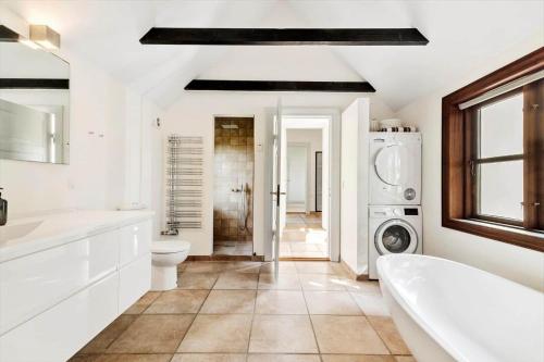 a bathroom with a tub sink and a washing machine at LF11977-Struer-Norskovvej-17 in Vemb