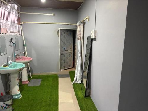 a bathroom with a sink and a shower with green carpet at RADHE RADHE HOMESTAy in Dithur